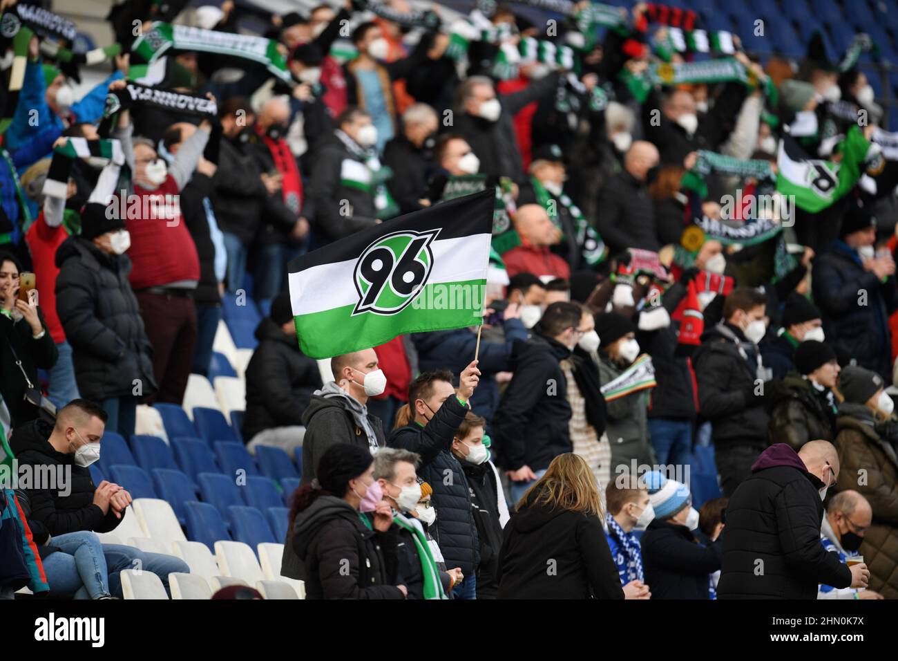 13 febbraio 2022, bassa Sassonia, Hannover: Calcio: 2nd Bundesliga, giorno di incontro 22: Hannover 96 - SV Darmstadt 98 all'HDI Arena. Un fan di Hannover 96 detiene una bandiera della sua squadra di calcio negli stand. Per la partita sono ammessi 5000 spettatori a causa delle norme per il contenimento della pandemia di Corona. Foto: Daniel Reinhardt/dpa - NOTA IMPORTANTE: In conformità con i requisiti della DFL Deutsche Fußball Liga e della DFB Deutscher Fußball-Bund, è vietato utilizzare o utilizzare fotografie scattate nello stadio e/o della partita sotto forma di immagini di sequenza e/o foto video-simili Foto Stock