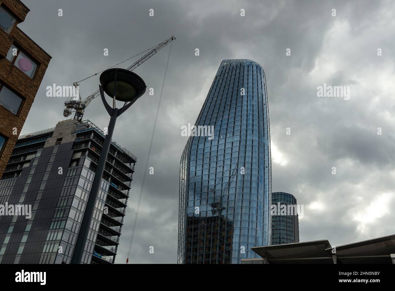 Una gru a torre e un nuovo edificio in costruzione si riflettono nelle pareti di vetro di una Blackfriars Tower nel centro di Londra Foto Stock