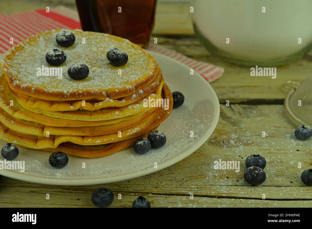 Pancake con mirtilli, sciroppo d'acero su un rustico sfondo bianco Foto Stock