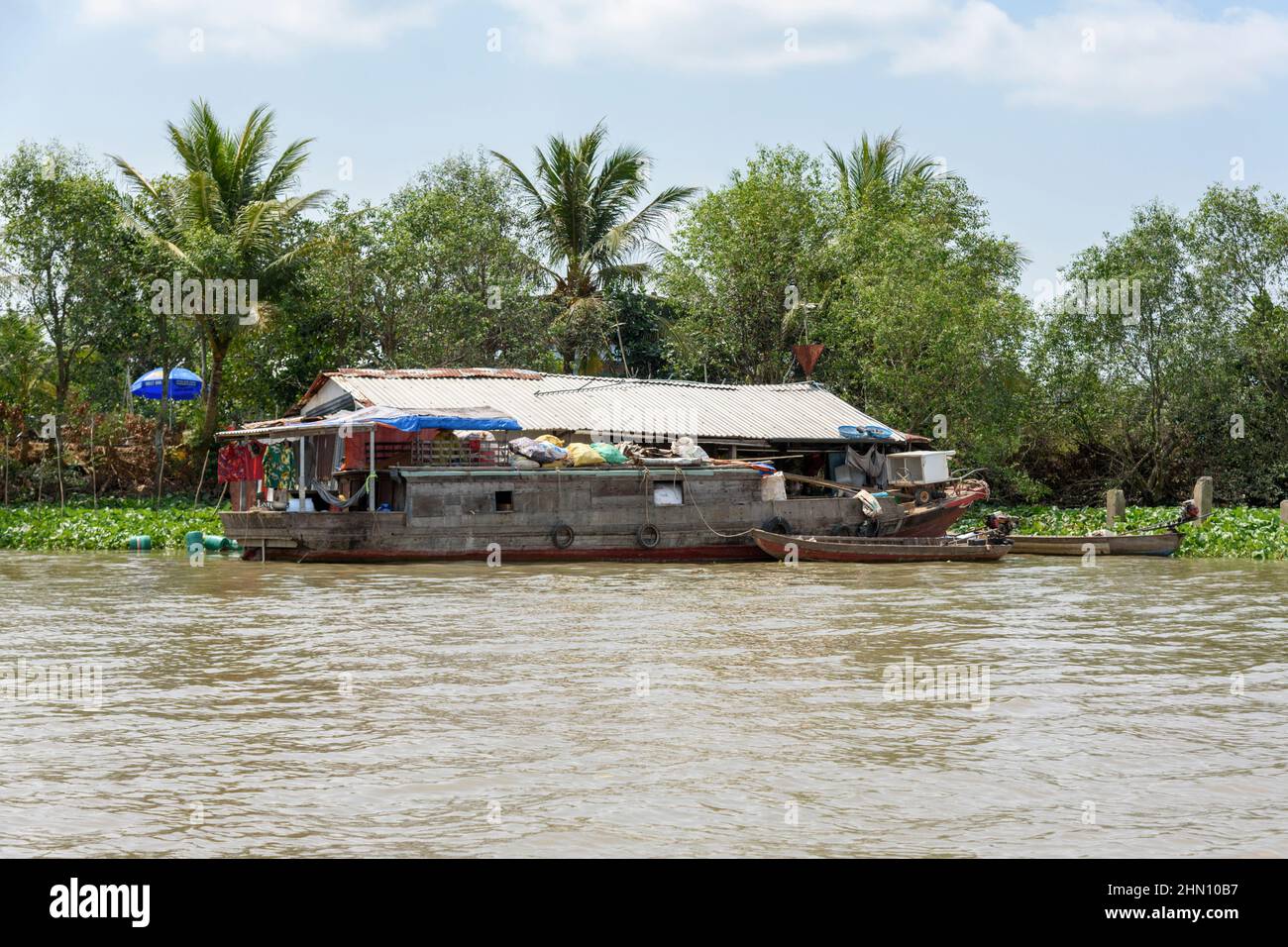 Casa galleggiante e barca di legno sul fiume Mekong, Delta del Mekong, Provincia di Vinh Long, Vietnam meridionale, Asia sudorientale Foto Stock
