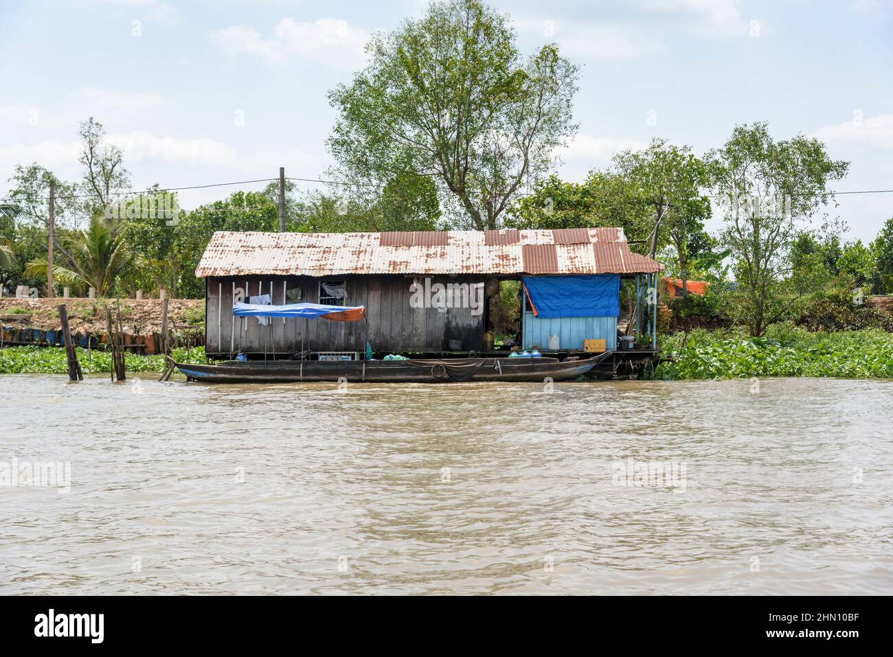 Casa galleggiante e barca di legno sul fiume Mekong, Delta del Mekong, Provincia di Vinh Long, Vietnam meridionale, Asia sudorientale Foto Stock