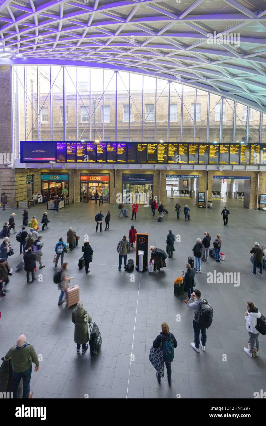 Aeroporto London Kings Cross Railway Station; passeggeri che guardano l'imbarco delle partenze, stazione Kings Cross Rail London UK Foto Stock