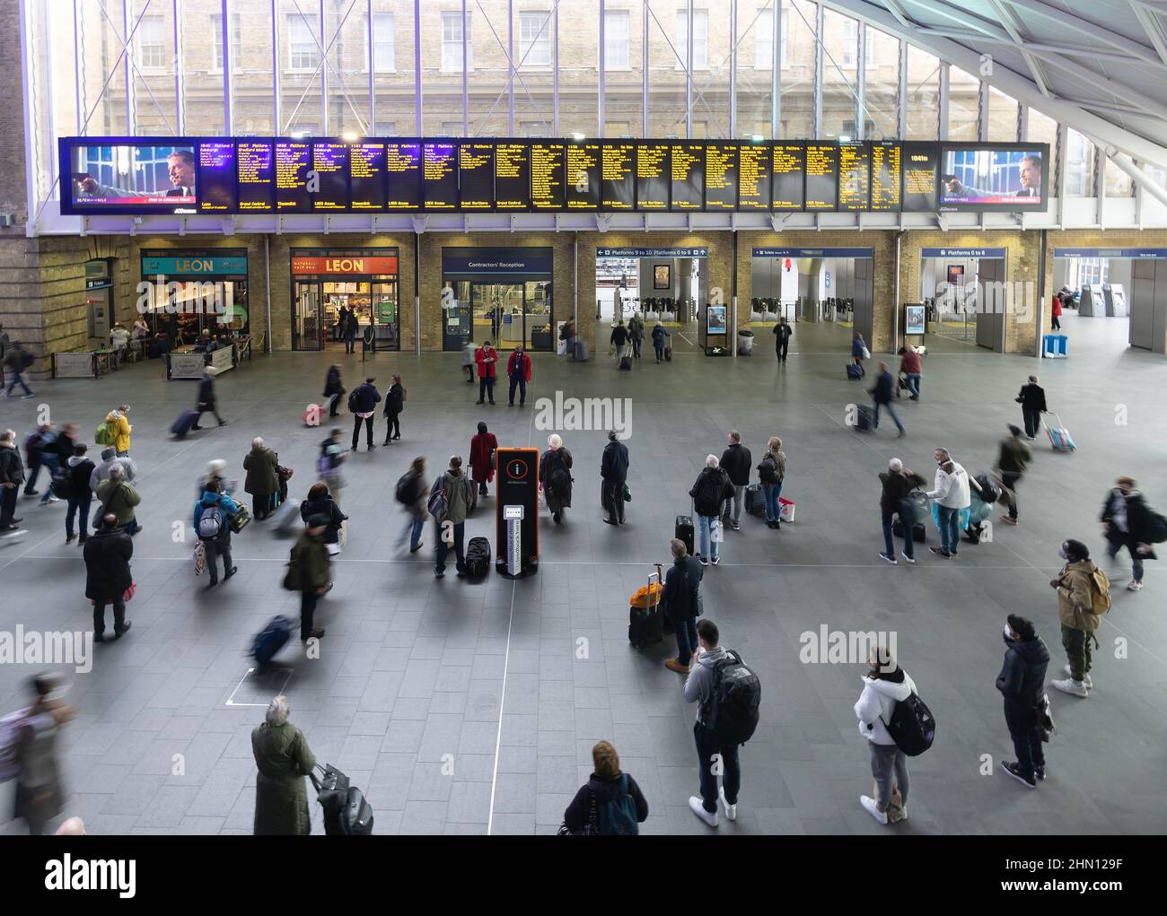 Aeroporto London Kings Cross Station; passeggeri che guardano l'imbarco delle partenze, stazione Kings Cross Rail London UK Foto Stock