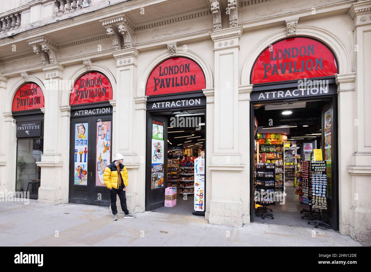 London Pavilion Piccadilly Circus London UK; un uomo che si trova fuori dall'ingresso della galleria commerciale Now, London City Centre, London UK Foto Stock
