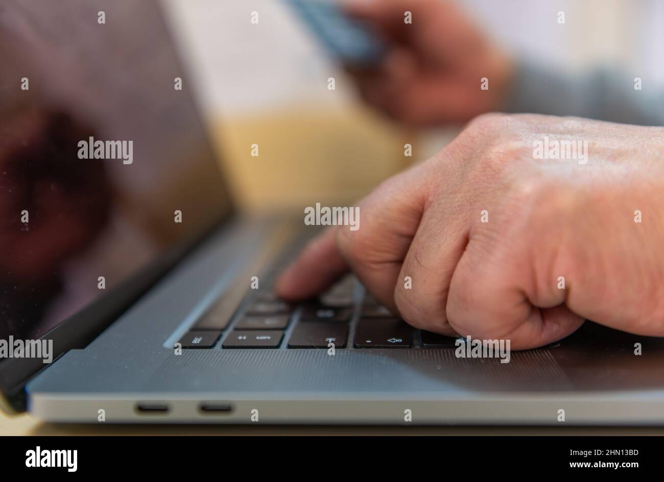 Una persona che utilizza una carta di pagamento per pagare online. Foto Stock