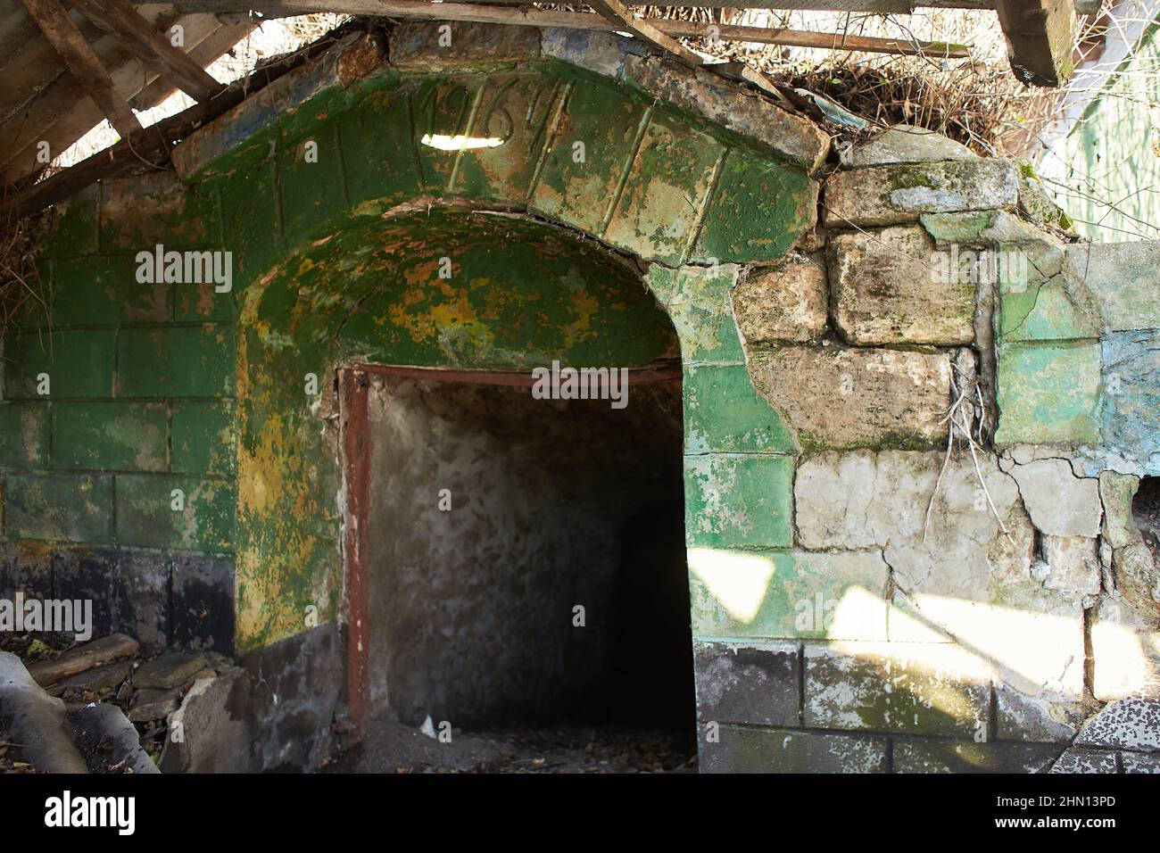 Antica porta d'ingresso del seminterrato abbandonato in villaggio su sfondo naturale. Vecchia casa tradizionale in Moldavia. Foto Stock