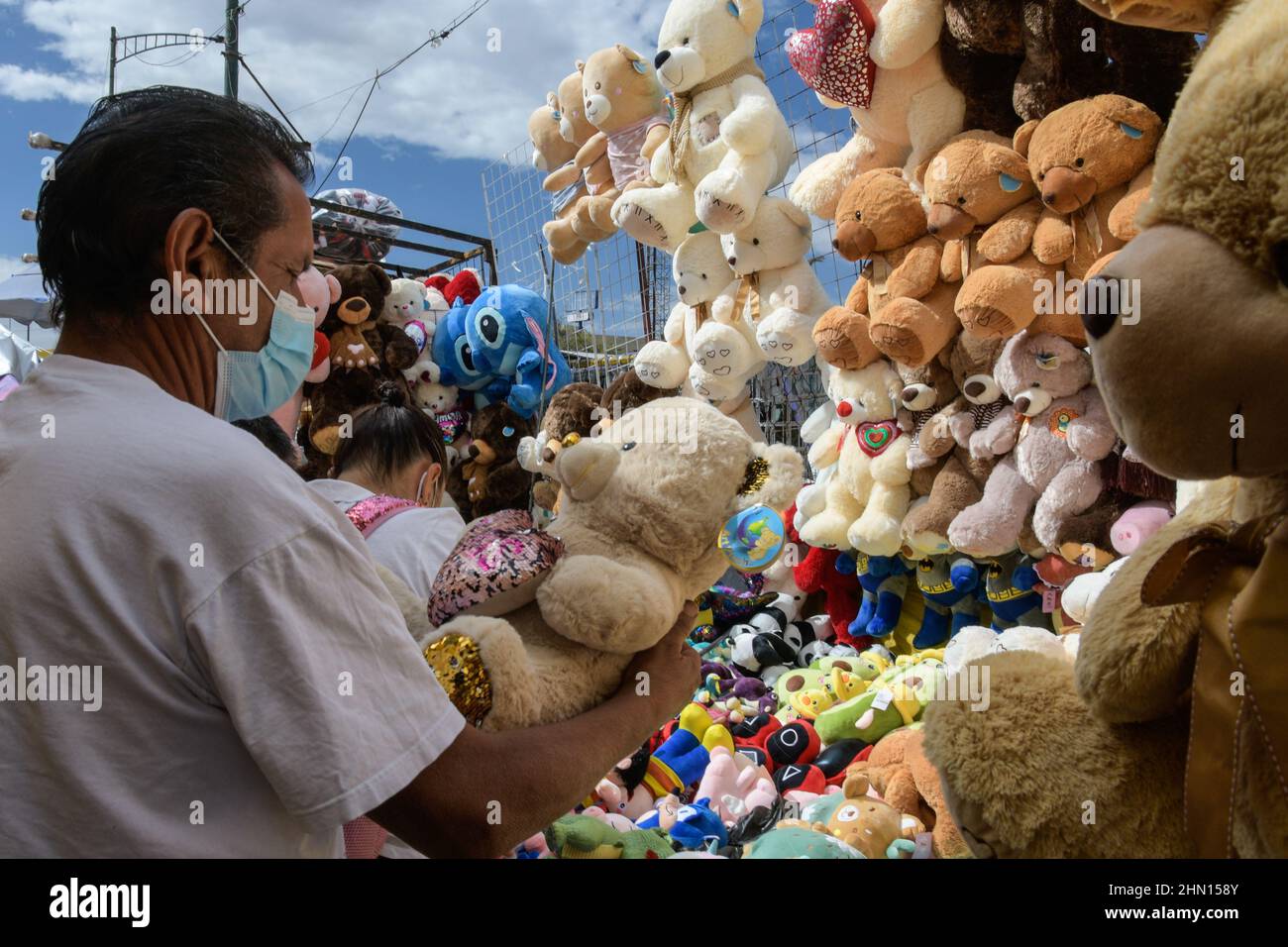 Non esclusiva: CITTÀ DEL MESSICO, MESSICO - 11 FEB 2022: I venditori ambulanti offrono arrangiamenti di fiori e orsacchiotti in un mercato all'aperto in occasione della Th Foto Stock