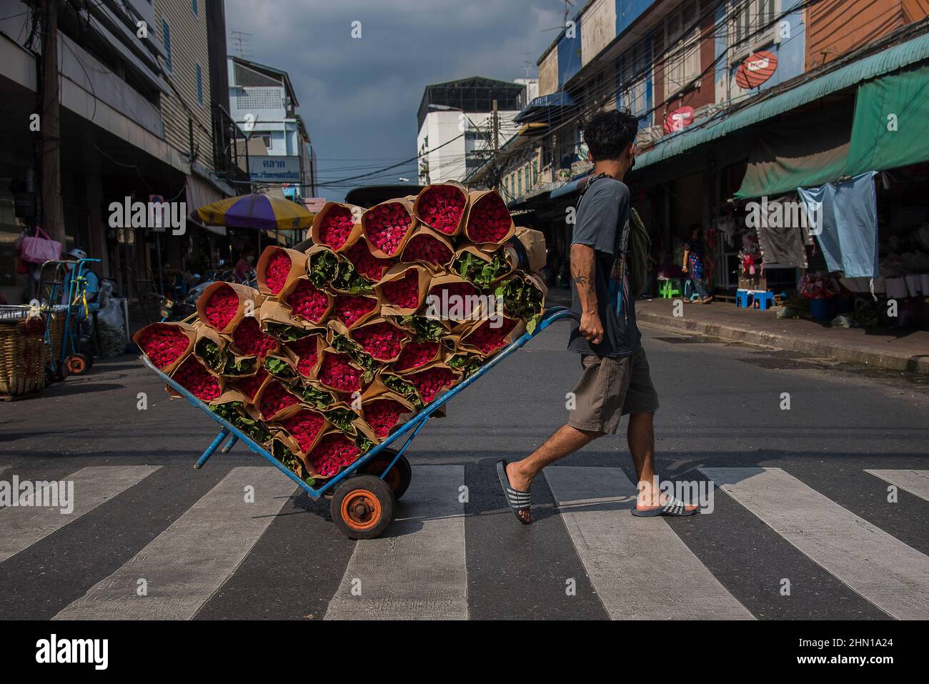 Bangkok, Tailandia. 13th Feb 2022. Un lavoratore thailandese ha visto tirare un carrello con rose in vendita prima di San Valentino al mercato dei fiori Pak Klong Talad a Bangkok. Credit: SOPA Images Limited/Alamy Live News Foto Stock