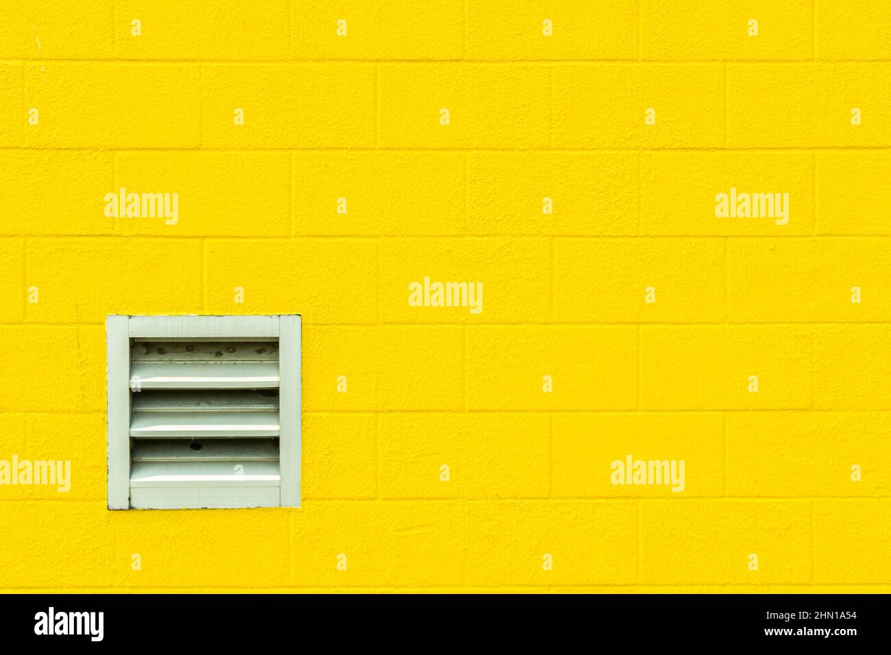 sfondo grafico astratto concetto giallo brillante cinder blocco parete con spazio di ventilazione copia Foto Stock