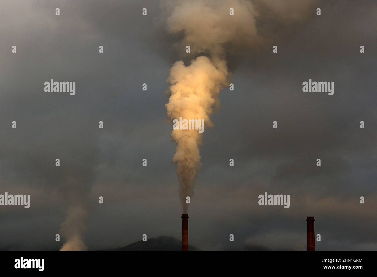 Camini industriali pesanti che producono fumo e fuoco. Illustrazione dell'inquinamento atmosferico e danni agli organi respiratori. Riscaldamento globale e industria del carbone Foto Stock