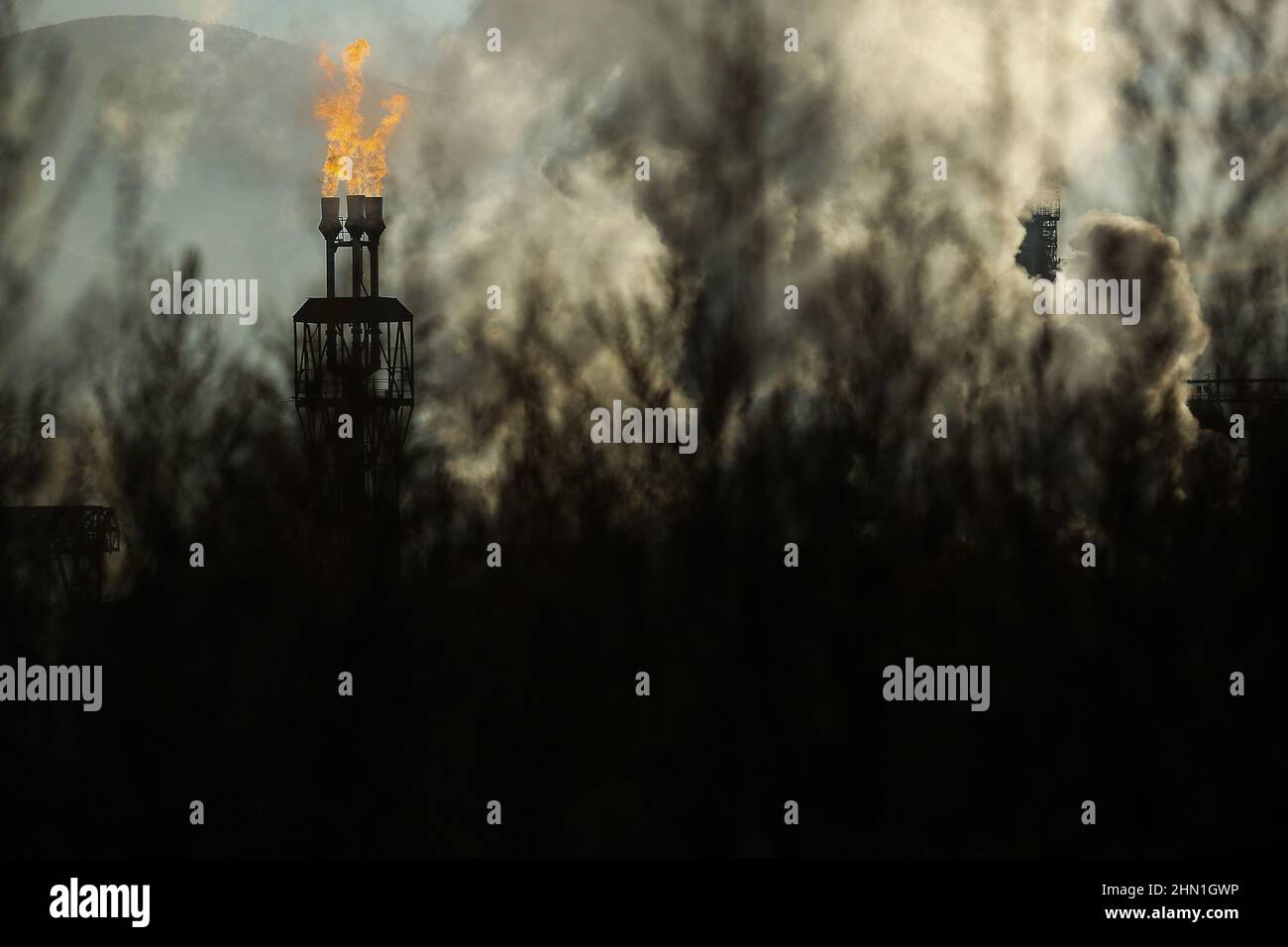 Camini industriali pesanti che producono fumo e fuoco. Illustrazione dell'inquinamento atmosferico e danni agli organi respiratori. Riscaldamento globale e industria del carbone Foto Stock
