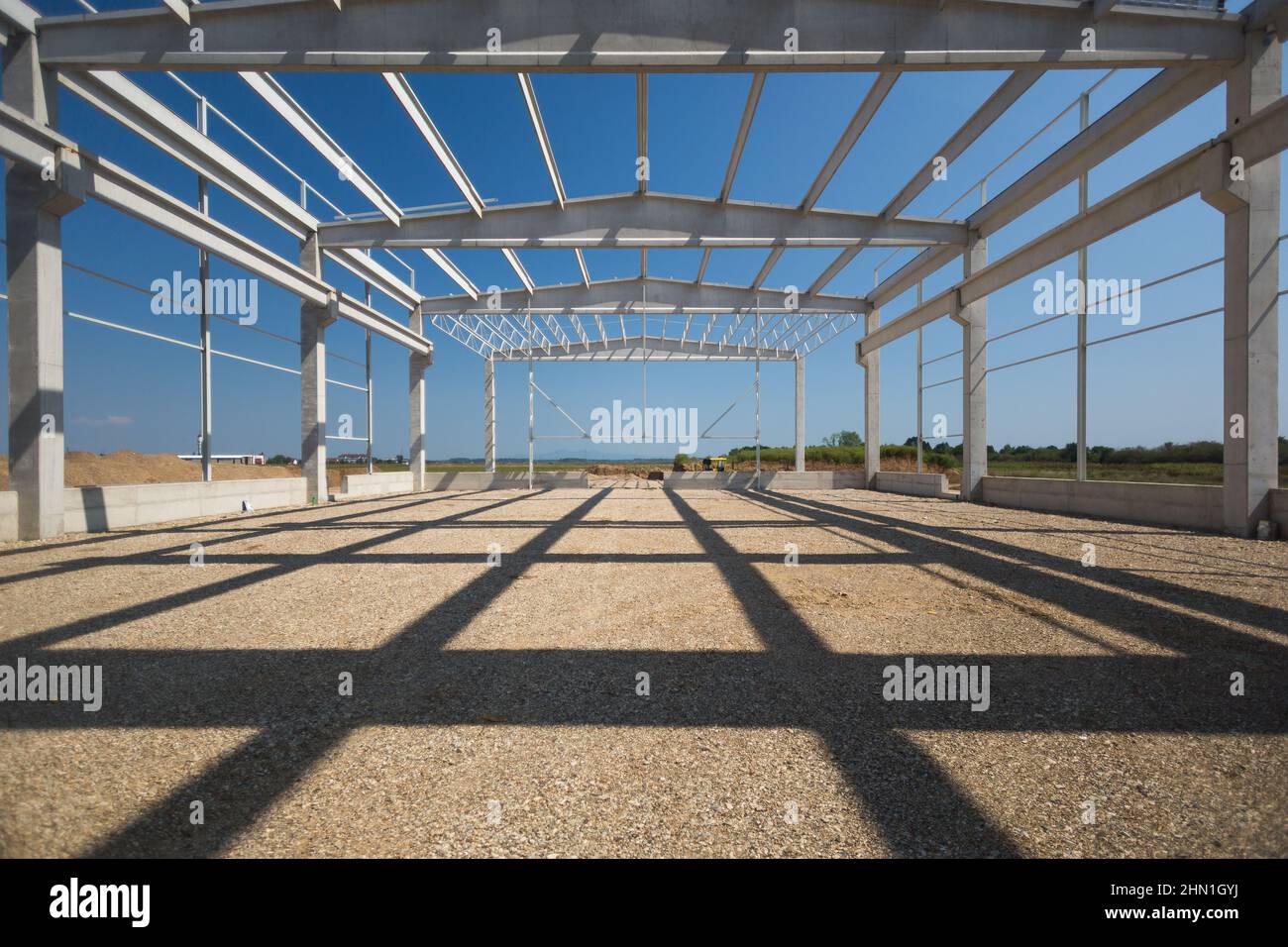 Grande cantiere all'inizio del progetto. Grande industria hall in produzione. Pilastri in acciaio e fondazioni in calcestruzzo Foto Stock