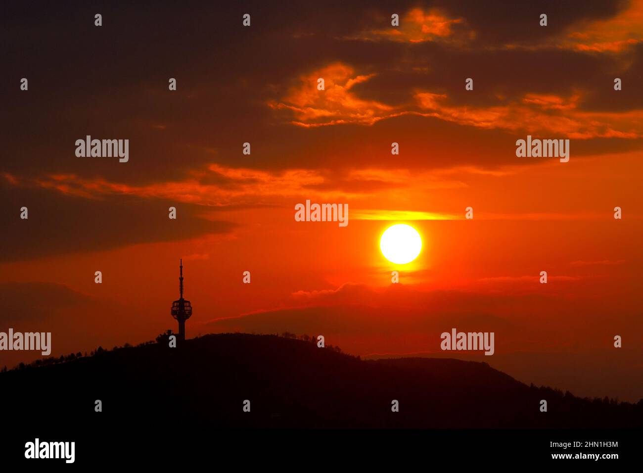Vista della Torre Hum sul Monte Hum al tramonto, Sarajevo, Bosnia ed Erzegovina. Cielo rosso, sagoma del paesaggio urbano Foto Stock