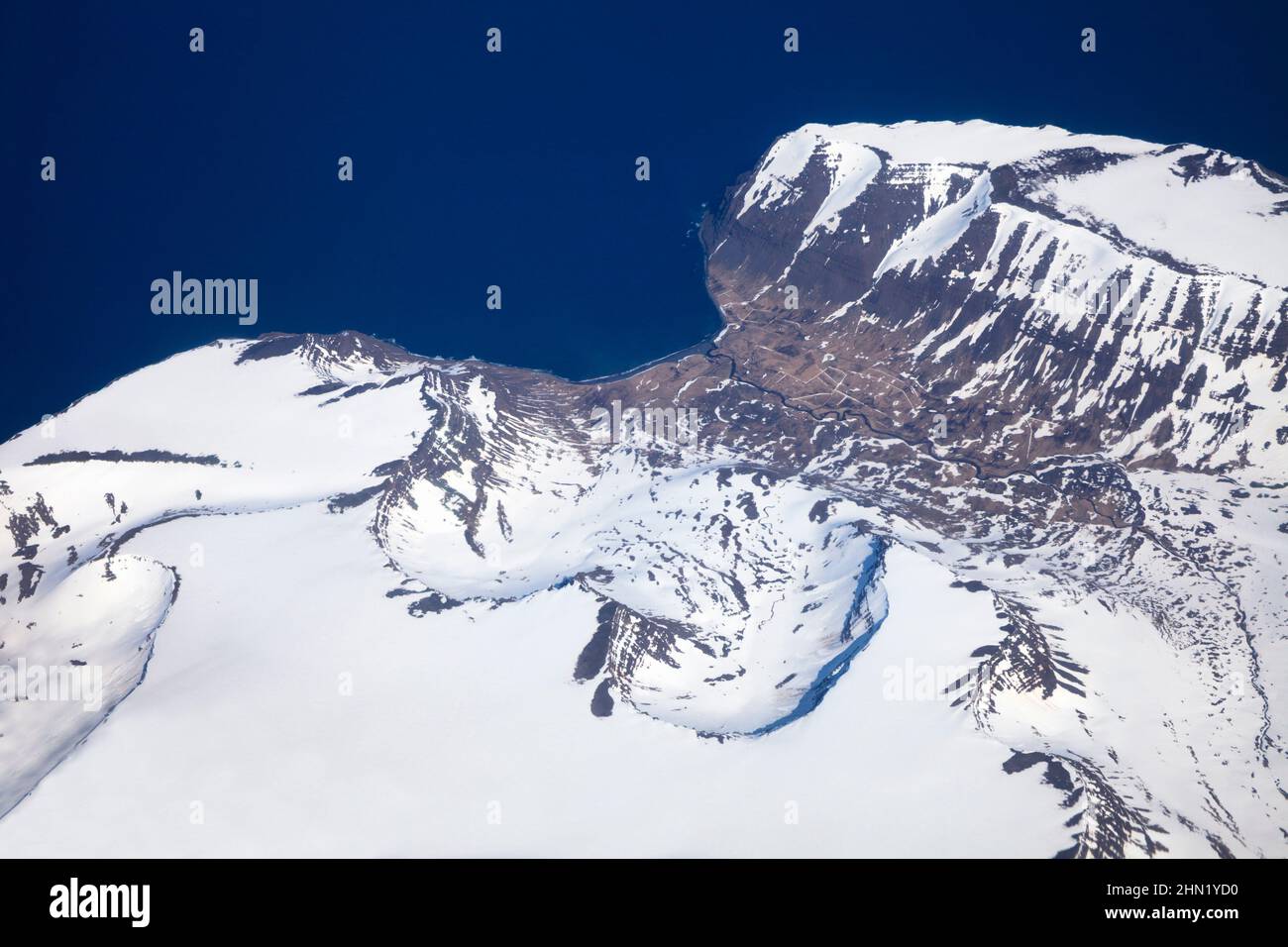 Islanda, vista aerea che mostra la costa occidentale e il terreno montuoso con campi di neve a maggio Foto Stock