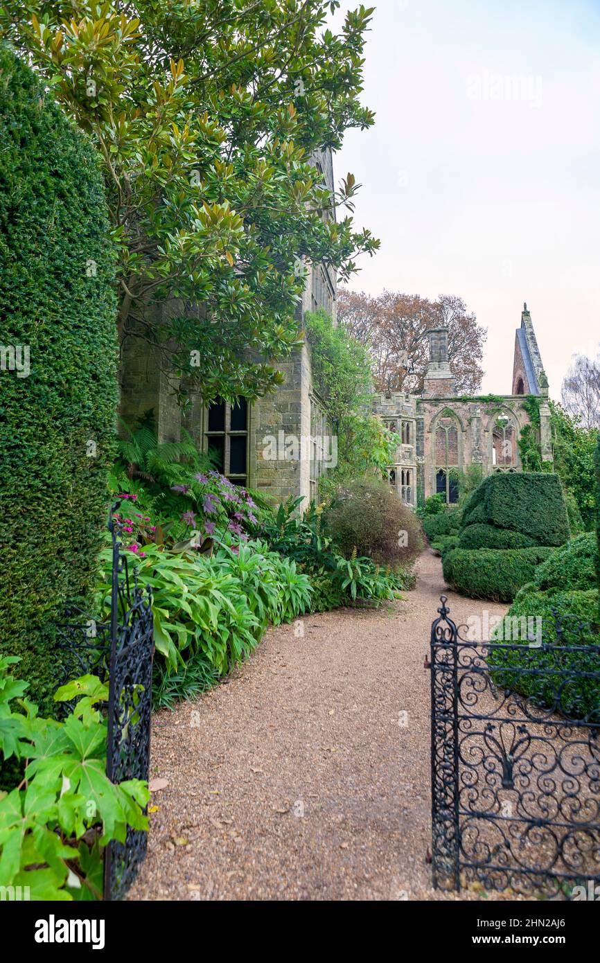 Le romantiche rovine di Nymans, distrutte dal fuoco nel 1947, e ora circondate da piante lussureggianti ed esotiche: West Sussex, Regno Unito Foto Stock