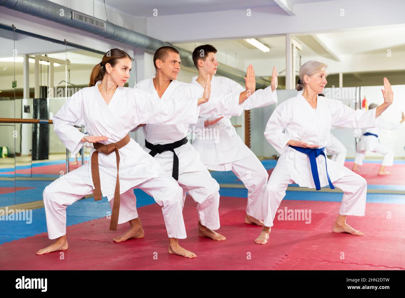 La gente in kimonos che pratica i pugni durante l'allenamento delle arti marziali Foto Stock