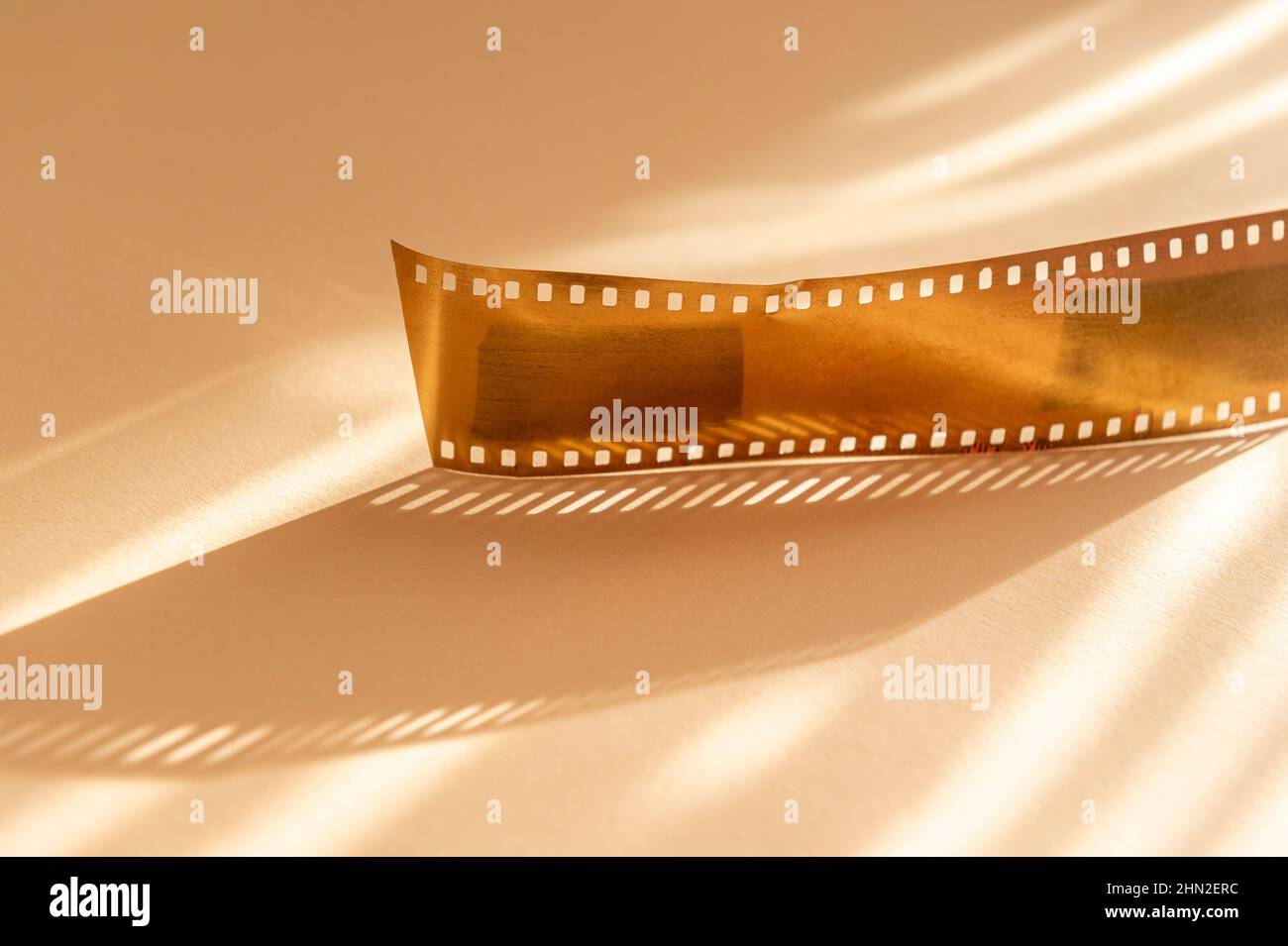 Strisce di film in oro su sfondo beige. Poster a tema multimediale orizzontale, biglietti d'auguri, intestazioni, sito Web e app Foto Stock