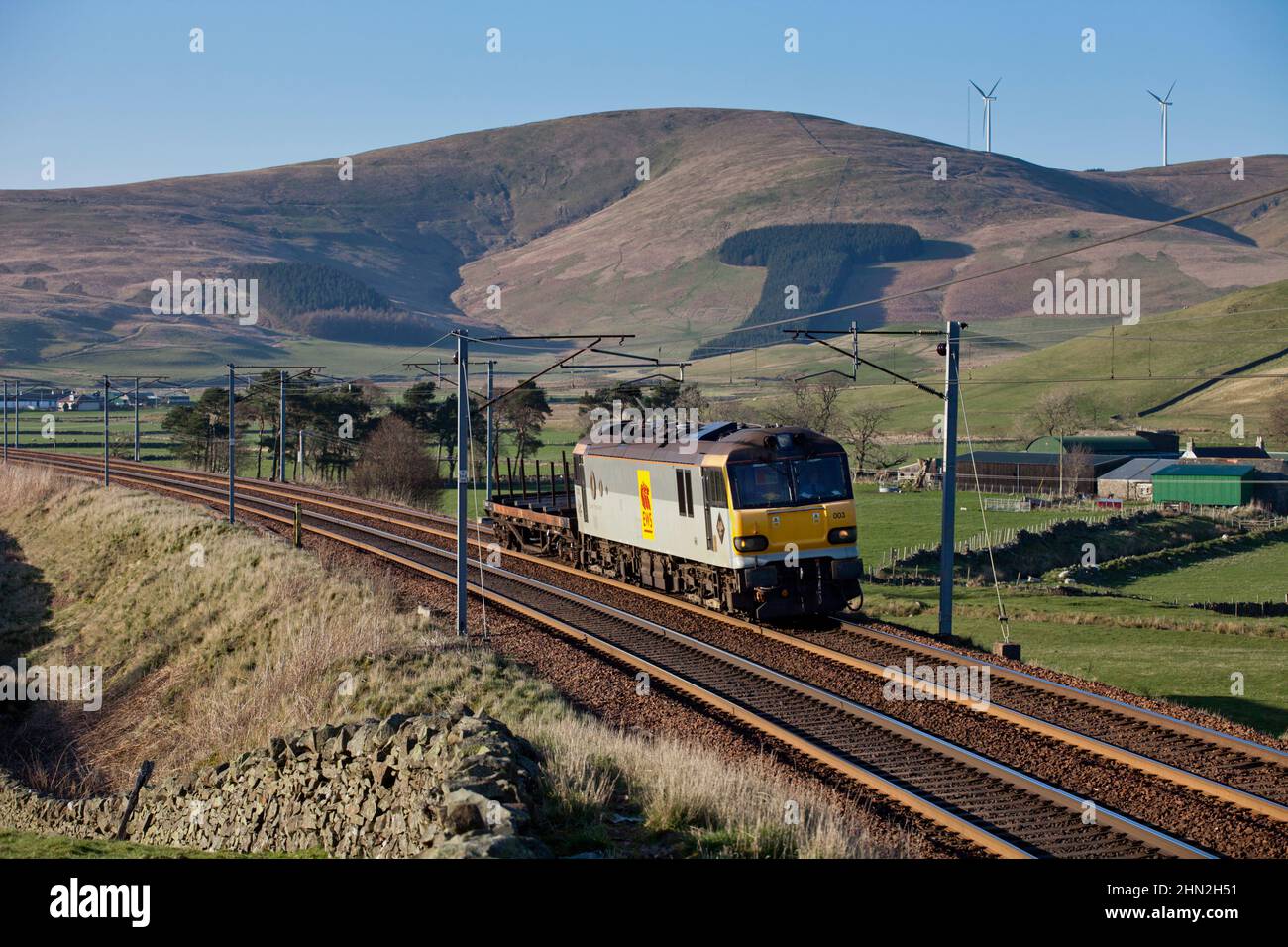 Locomotiva elettrica di classe 92 che trasporta un treno merci corto di 1 carri in acciaio a Crawford nella valle superiore di Clyde sulla linea principale della costa occidentale, Scozia Foto Stock