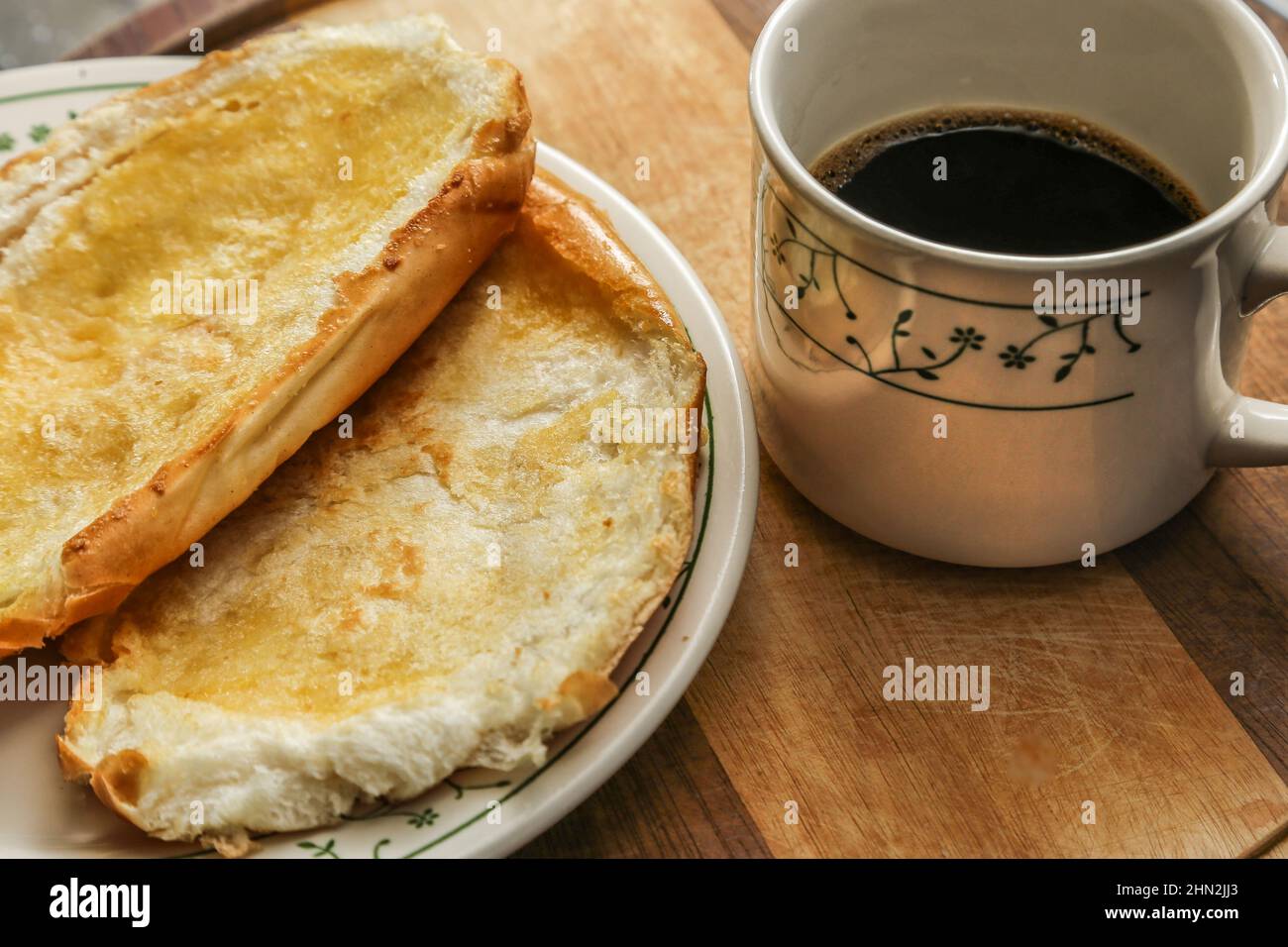 Goiânia, Goias, Brasile – 13 febbraio 2022: Due ciambelle sul piatto e una tazza di caffè su una superficie di legno. Foto Stock