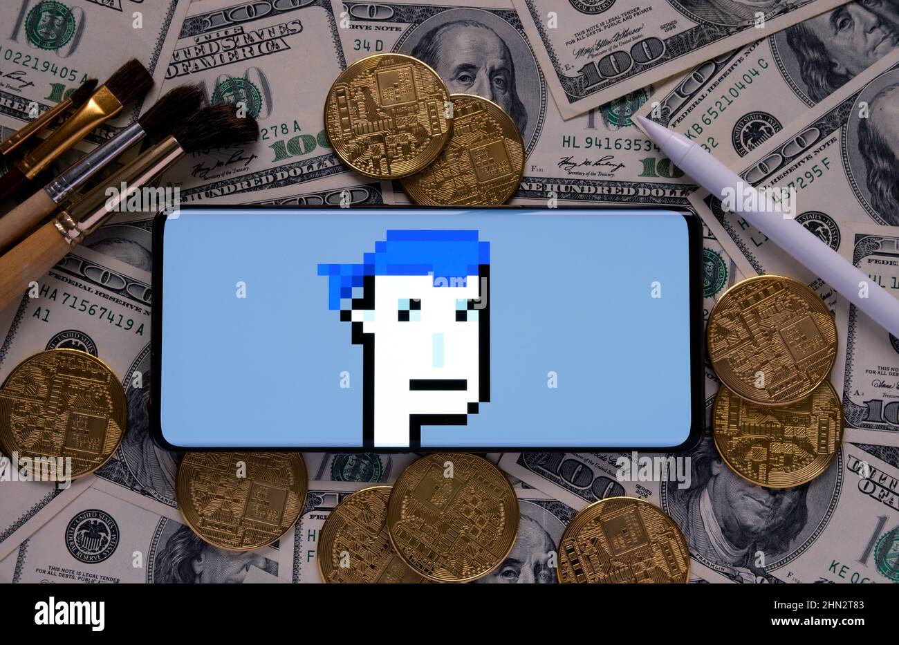 NFT Cryptopunk 5822 forma Larva Labs visto sullo schermo di dispositivo mobile messo su dollari con pennelli di concatenazione, stilus penna e cripto token. Concetto Foto Stock