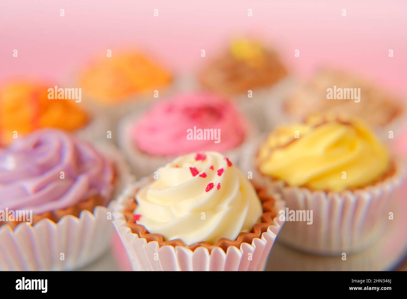 Dessert alla panna. Crema cupcakes.cakes su sfondo rosa. Tavola dolce assortita. Dolci e dessert. Prodotti da forno Foto Stock