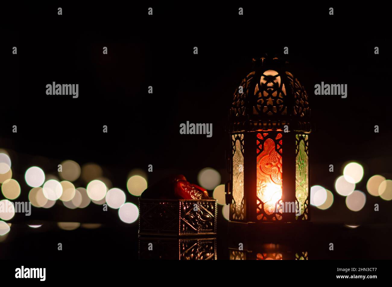 Lanterna e datteri frutta con bokeh chiaro in sfondo scuro per la festa musulmana del mese santo di Ramadan Kareem. Foto Stock