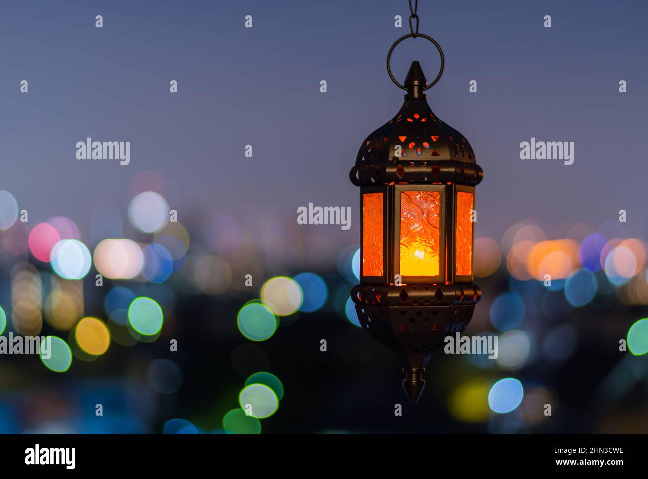 Lanterna appesa con cielo notturno e sfondo chiaro bokeh della città per la festa musulmana del mese santo di Ramadan Kareem. Foto Stock