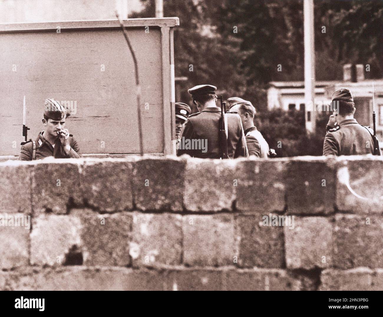 Foto d'epoca della crisi di Berlino del 1961: Costruire il muro truppe della Germania orientale e gruppo di polizia insieme dietro il muro costruito dai comunisti per sigillare Foto Stock