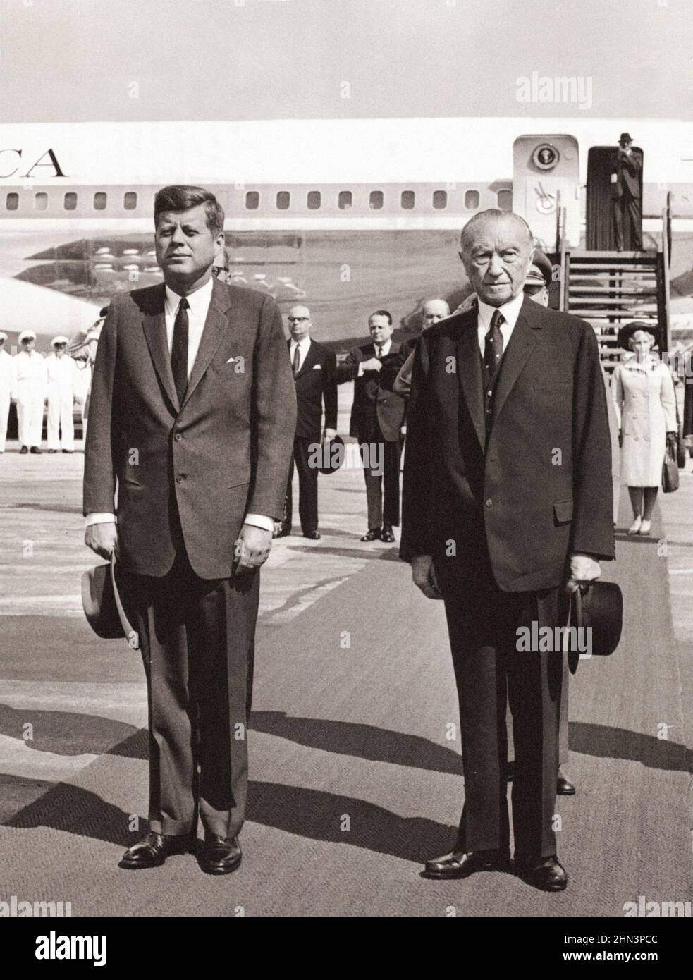 Foto d'epoca della crisi di Berlino del 1961: Costruire il Muro. Il presidente Kennedy e il cancelliere Adenauer si levano in piedi all'attenzione durante il gioco degli Stati Uniti Foto Stock