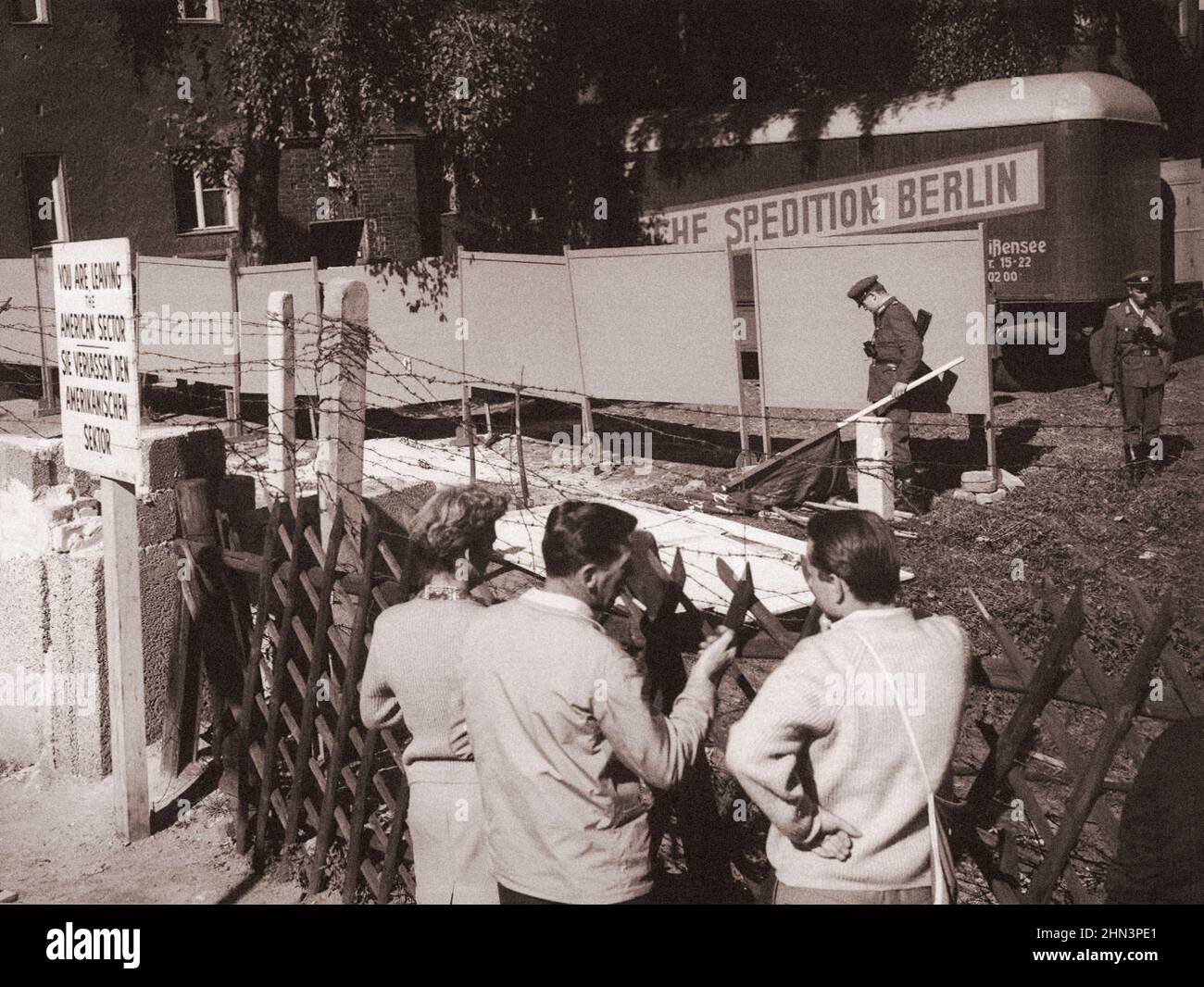 Foto d'epoca della crisi di Berlino del 1961: Costruire il Muro. Le Guardie della Germania orientale hanno messo in su i pannelli grandi per nascondere le loro azioni dagli occhi e dalle telecamere dell'ovest Foto Stock
