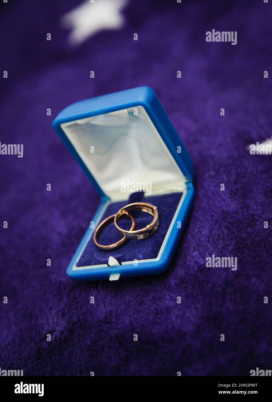 due anelli d'oro in scatola aperta su sfondo scuro. orientamento verticale. Foto Stock