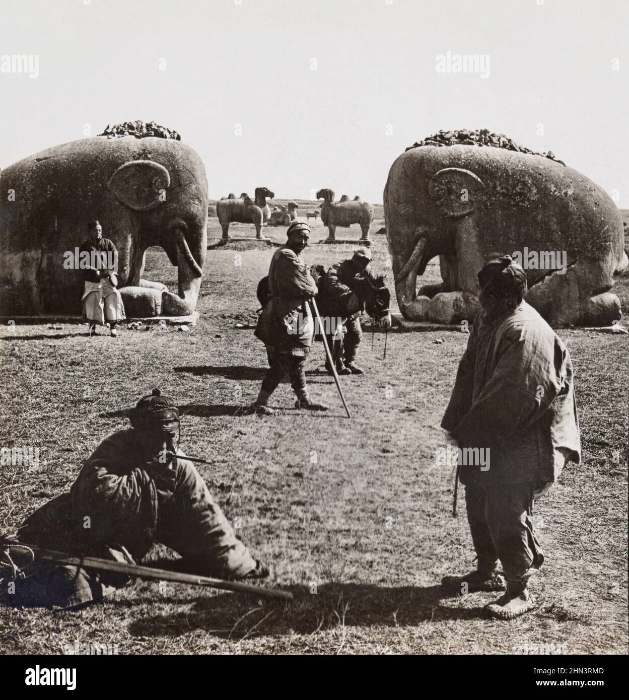 Foto d'epoca degli agricoltori cinesi vicino all'enorme figura di pietra degli elefanti addormentati. Ming Tumbs. Nanking, Cina settentrionale. 1919 Foto Stock