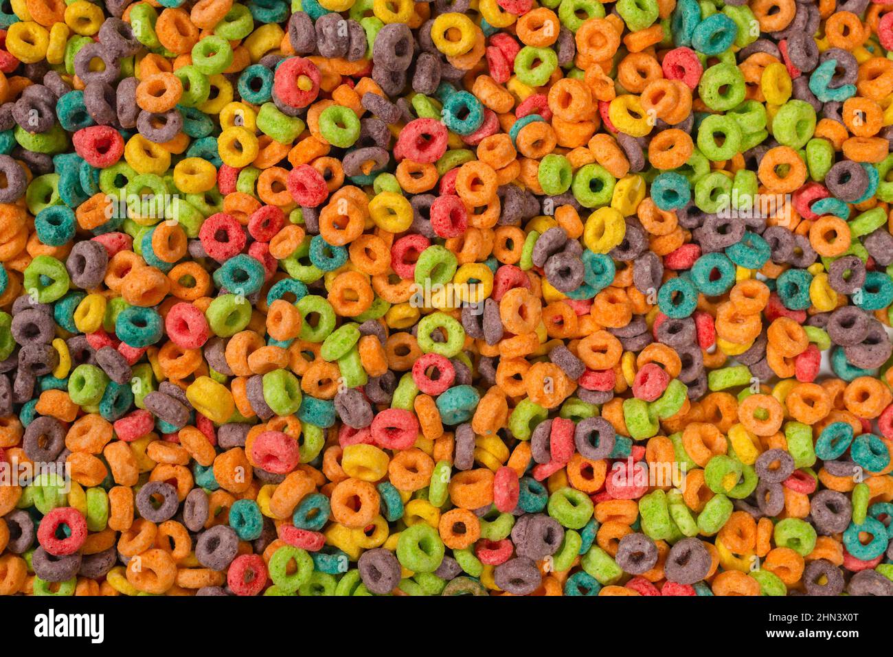 Dolci fiocchi multicolore, anelli di cereali come sfondo. Foto Stock