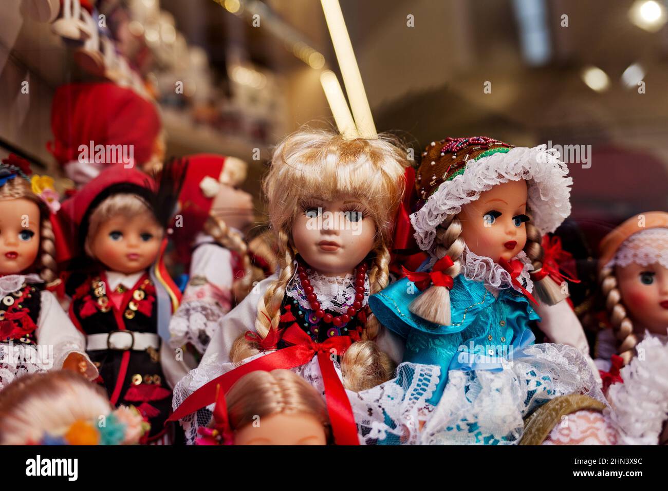 un sacco di belle bambole in abiti sulla vetrina del negozio. Bambola Foto Stock
