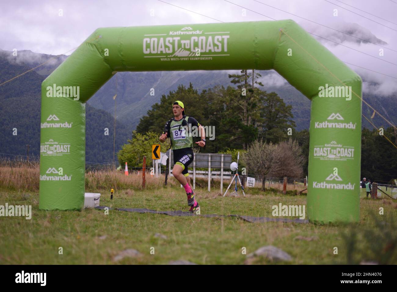 ARTHURS PASS, NUOVA ZELANDA, 12 FEBBRAIO 2022; concorrente 87 passa attraverso l'inizio ufficiale della corsa di montagna per il Triathlon Coast to Coast Foto Stock