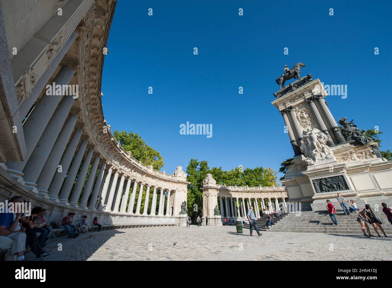 Monumento ad Alfonso nel Parque de El Retiro. Persone escap il sole caldo all'ombra del colonnato storico o galleria monumentale. Madrid, Spagna Foto Stock