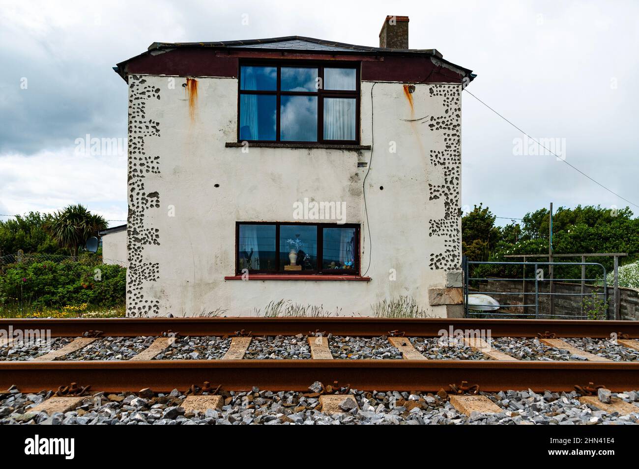 L'edificio abbandonato vicino alla ferrovia significa notti insonne. Casa dilapidata da una ferrovia o treni. La casa abbandonata trasmette il concetto di solitudine Foto Stock