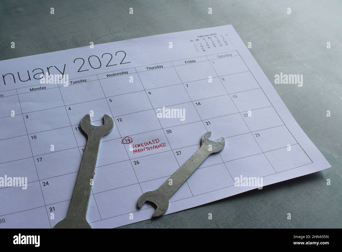 Concetto di manutenzione programmata. Chiave e calendario con testo MANUTENZIONE PROGRAMMATA Foto Stock