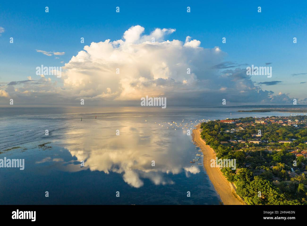 Spettacolare vista aerea dell'alba sopra la spiaggia di Sanur con una massiccia nuvola a Bali, Indonesia Foto Stock