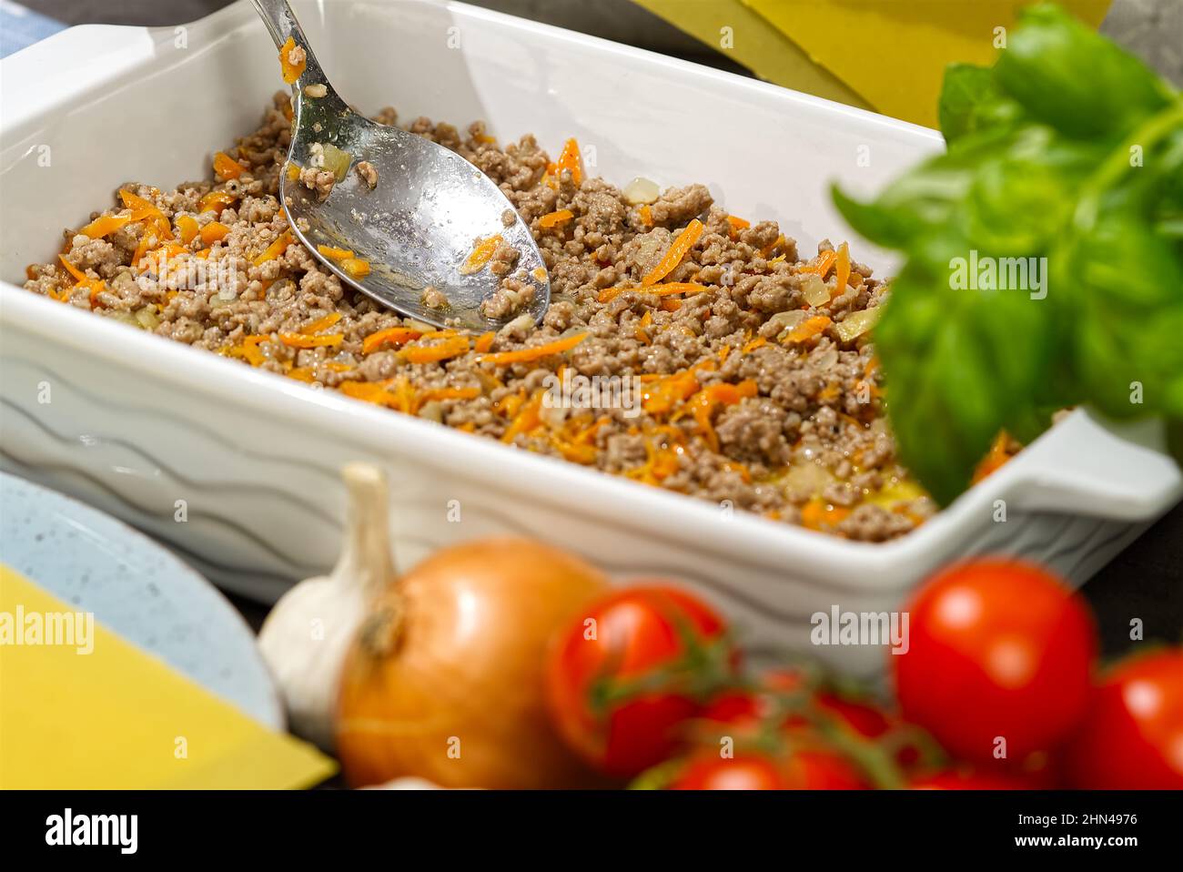 Donna che prepara lasagne di carne in cucina. Ricetta lasagna - cucina italiana Foto Stock