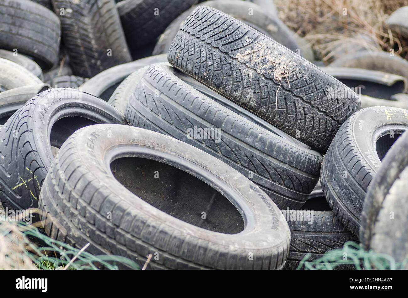 Un cumulo di pneumatici per auto danneggiati, vecchi, scartati per il riciclaggio. Foto Stock