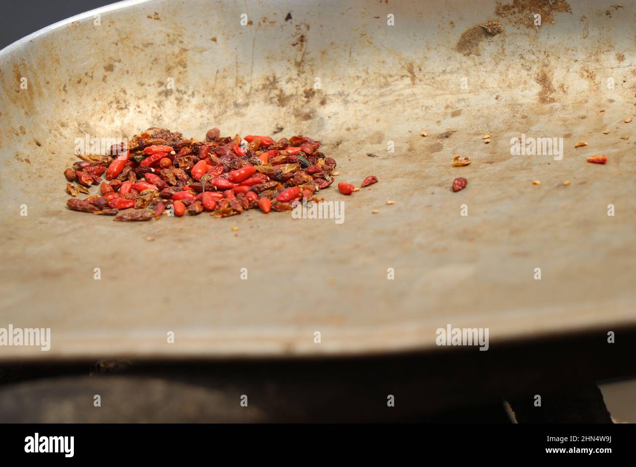 Peperoncini rossi asciutti su un winnow d'acciaio Foto Stock