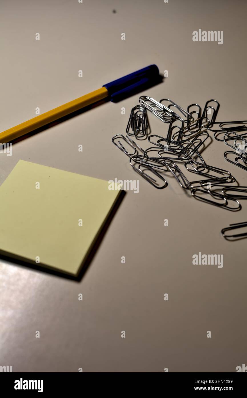Penna con blocco per appunti e clip su una scrivania Foto Stock