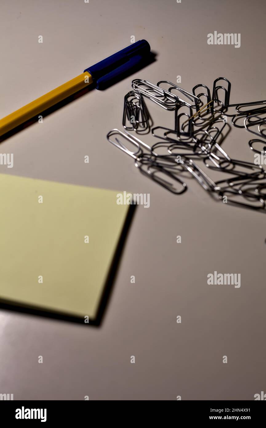 Penna con blocco per appunti e clip su una scrivania Foto Stock