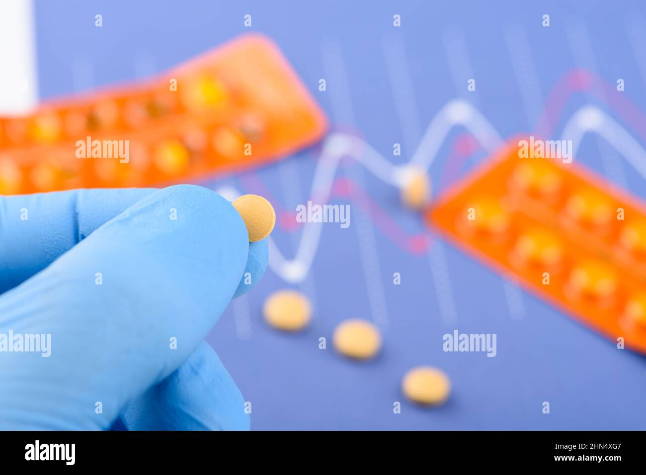 Scienziato tenere piccola pillola in una mano con blister su sfondo Foto Stock