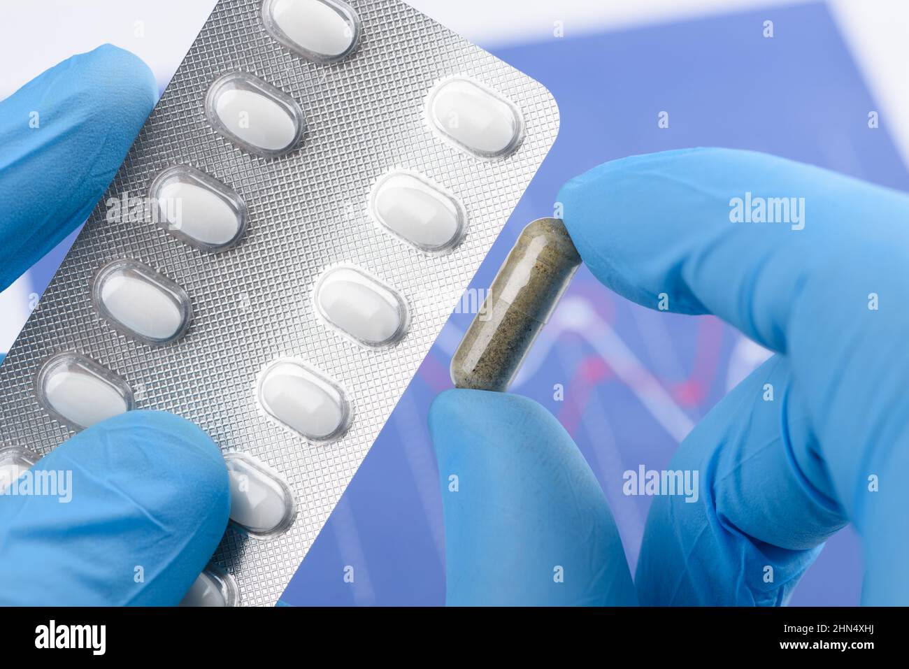 Lo scienziato tiene la capsula trasparente e il blister Foto Stock