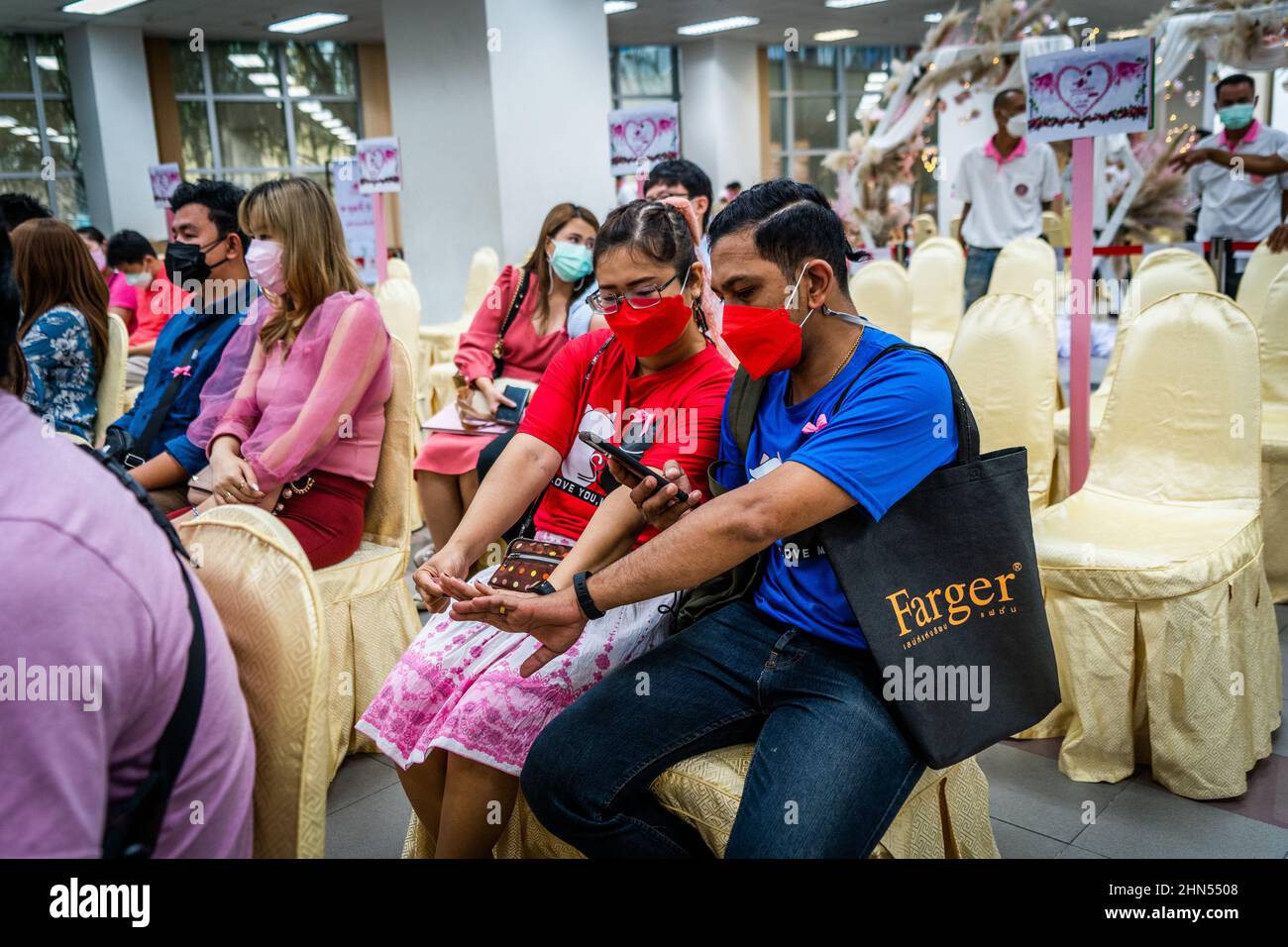 Una coppia scatta le foto dei loro anelli di nozze mentre attende il loro turno ad un evento di matrimonio di massa il giorno di San Valentino a Bangkok.le coppie si riuniscono per registrare legalmente il loro matrimonio durante l'evento di matrimonio di massa 'Lover New Normal @ Bangrak' il giorno di San Valentino a Bangkok. Anche se è comune per le persone legalizzare il loro matrimonio in tutti i 50 uffici distrettuali della città in questo giorno ogni anno, Bang Rak è tra i più popolari in quanto il suo nome assomiglia a 'luogo dell'Amore' nella lingua tailandese. (Foto di Matt Hunt/SOPA Images/Sipa USA) Foto Stock