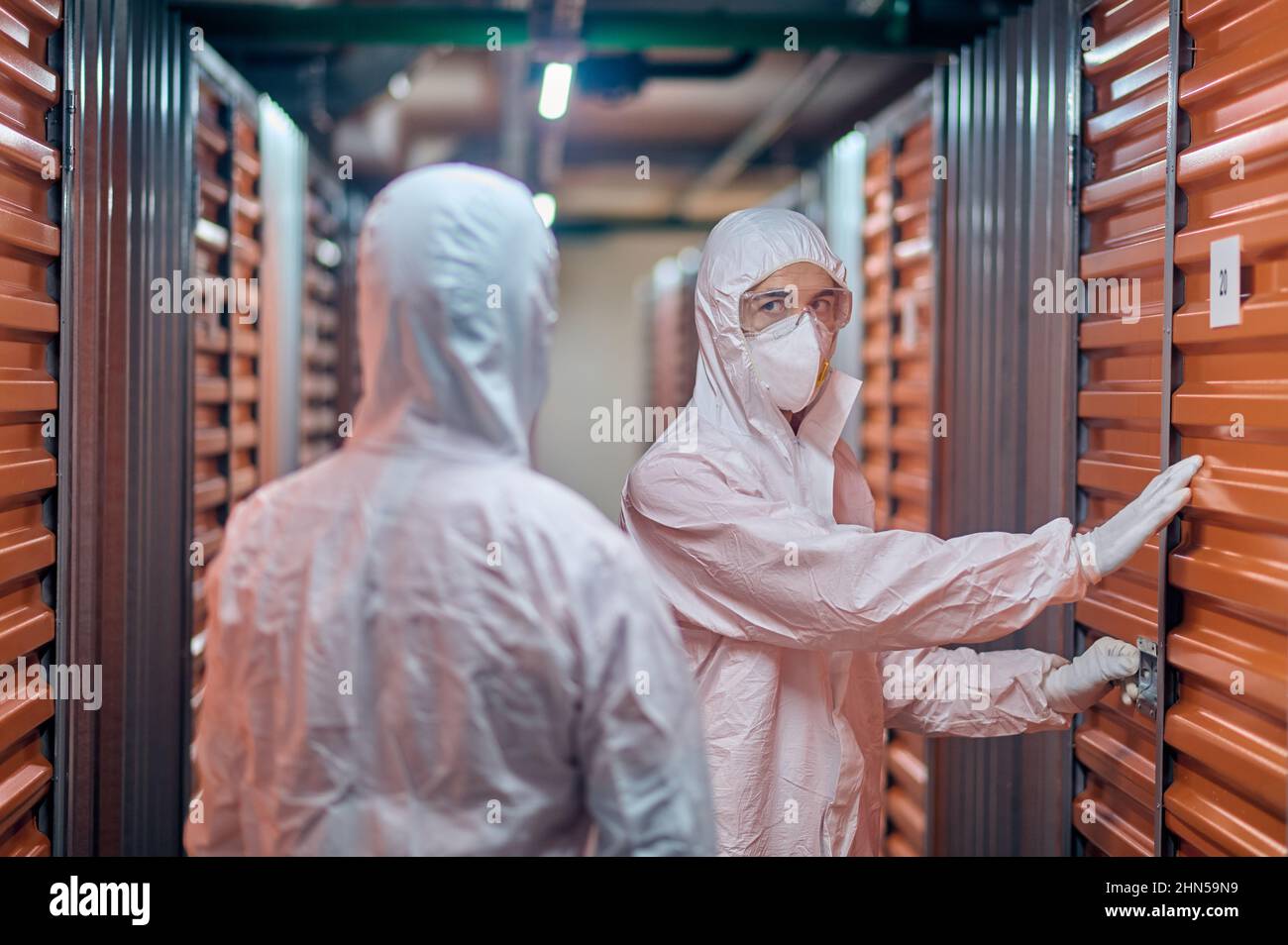 Storehouse worker che apre il blocco del contenitore per il suo client Foto Stock