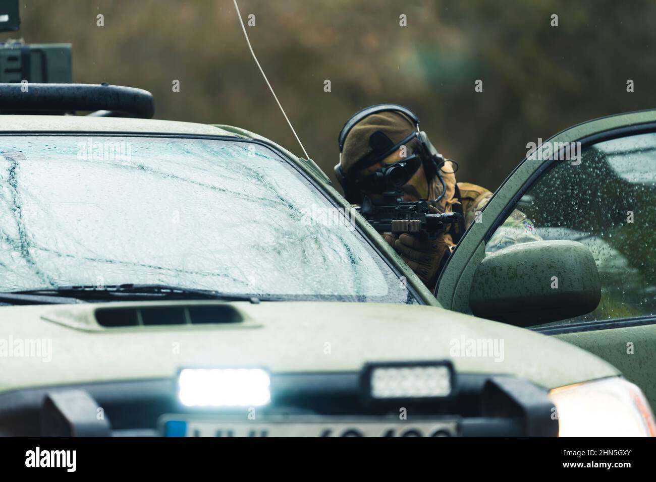 I militari nascondono e cercano di avvisare una minaccia utilizzando la copertura del camion. Foto di alta qualità Foto Stock