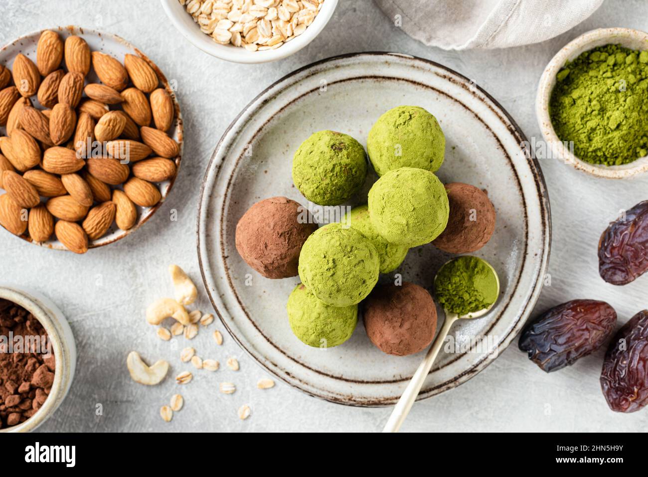 Palle di tè verde o tartufi di proteine vegane su un piatto. Dolci sani fatti in casa Foto Stock